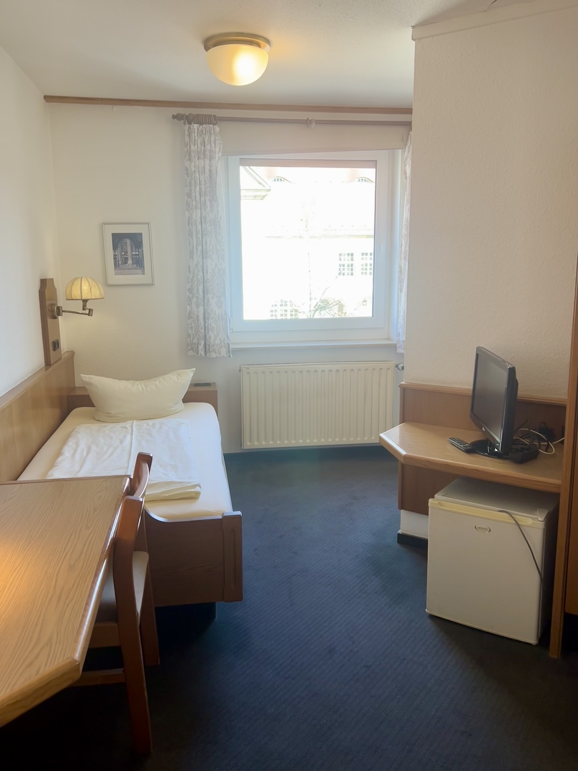 Einzelzimmer Überblick mit Schreibtisch und Fenster